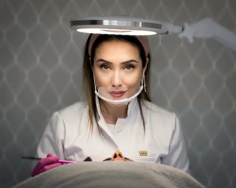 A Dra. Gabriela atendendo uma paciente sob a lupa de luz